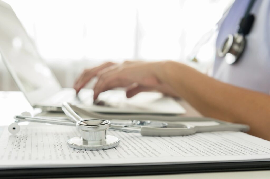 doctor typing on laptop